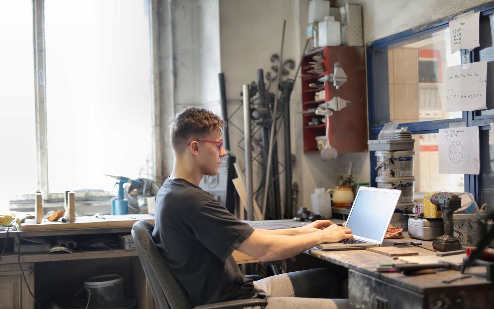 Dono de um pequeno negócio mexendo no notebook em seu próprio espaço de trabalho. Foto ilustrativa de banco de imagens, não um cliente real da Forni Web.